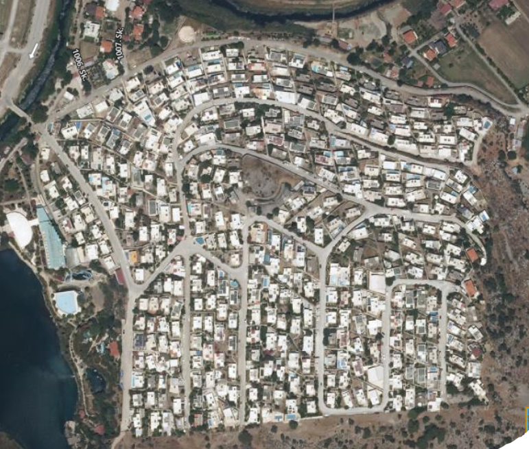 На снимке видно, как холм расположен рядом с жилыми районами, дорогами и другими местными объектами.